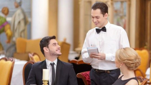 a waiter on his happy face taking the order of a couple on their limousine trip dinner date in chicago