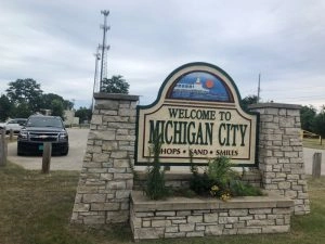 Welcome to Michigan City sign with stone base and surrounding greenery for limo service Michigan City Indiana